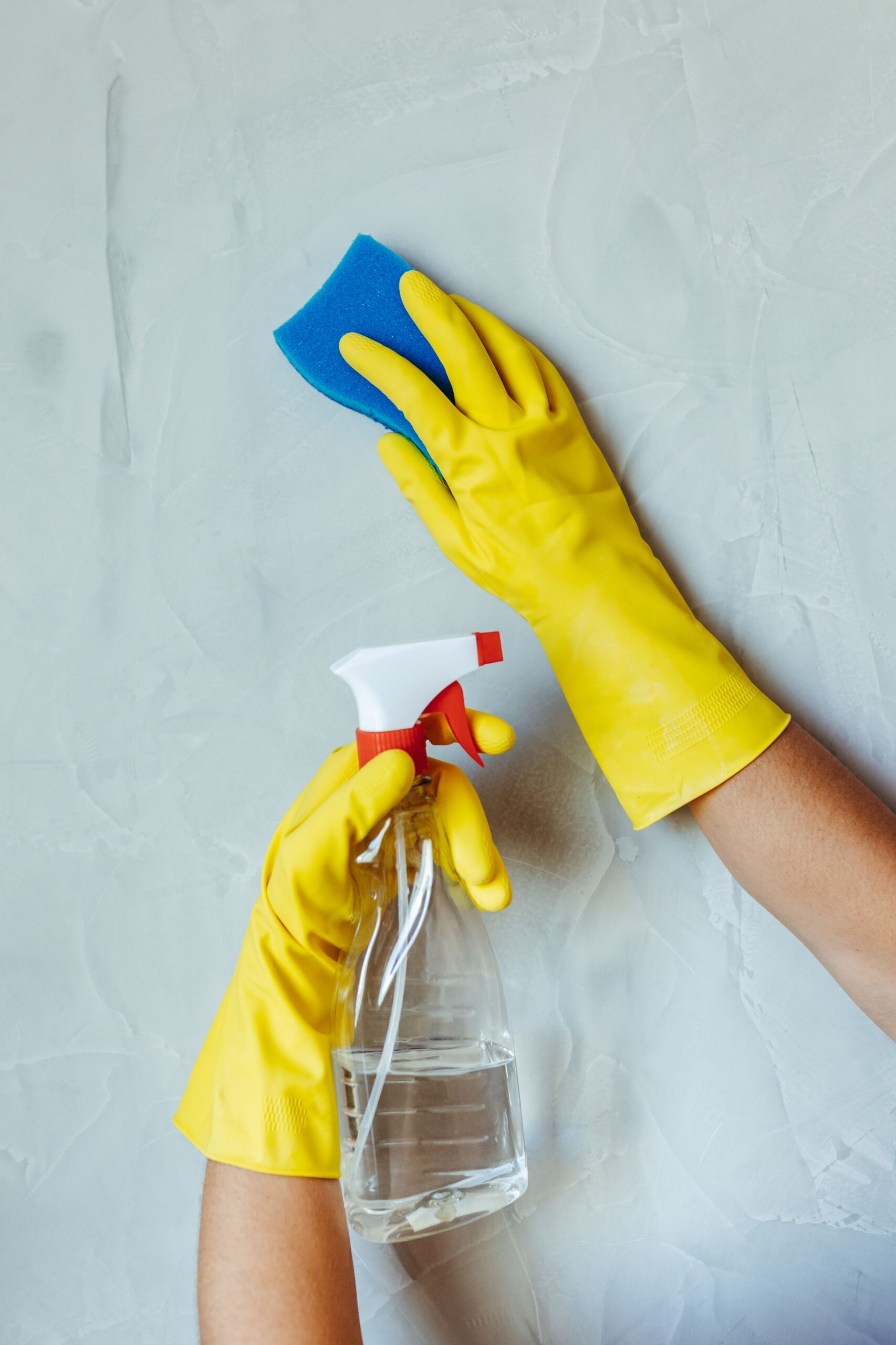 Facilitair medewerker van REDMO met schoonmaakspray
